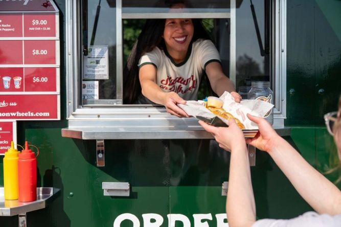 Stadium on Wheels Franchise employee serving delicious food